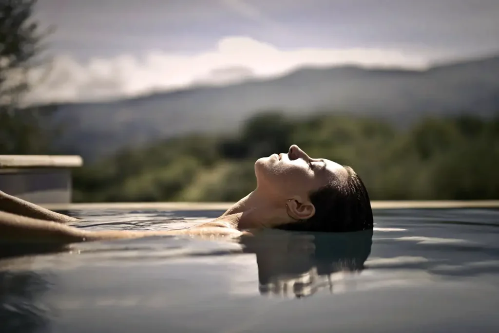 Femme qui se détend dans une piscine extérieure à Nice pour illustrer la gestion du stress et le bien-être mental.